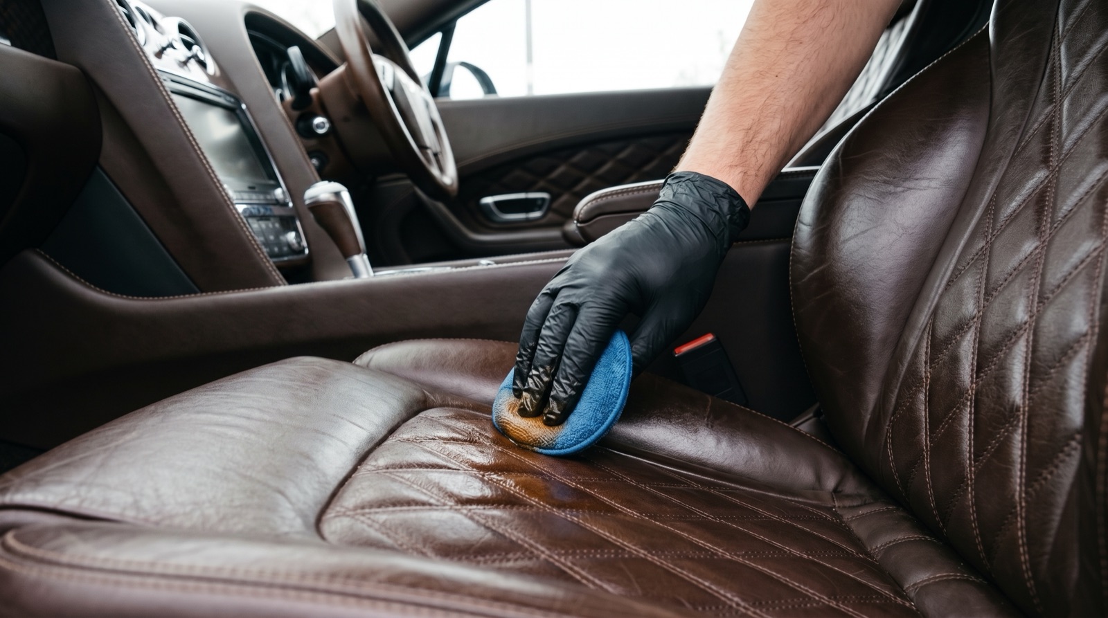 Leather seat conditioning and dashboard trim treatment during a car spa service
