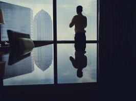 Elegant fiance standing near window. Businessman in a hotel room